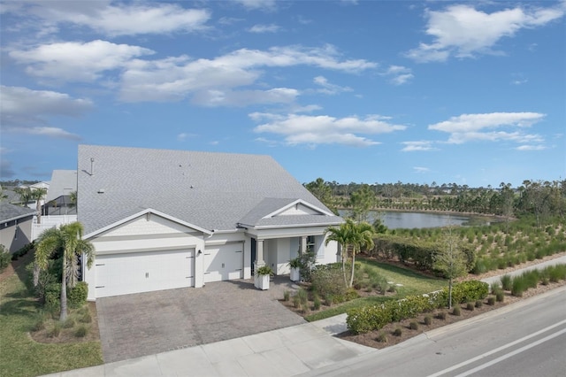 view of front facade featuring a garage and a water view