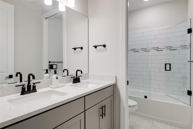 full bathroom featuring toilet, tiled shower / bath combo, vanity, and tile patterned flooring