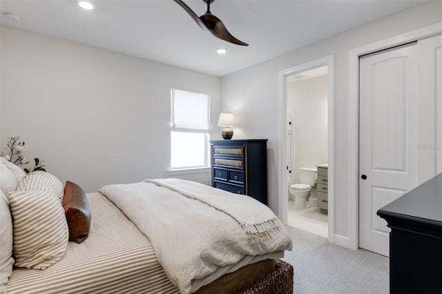 carpeted bedroom with connected bathroom, ceiling fan, and a closet