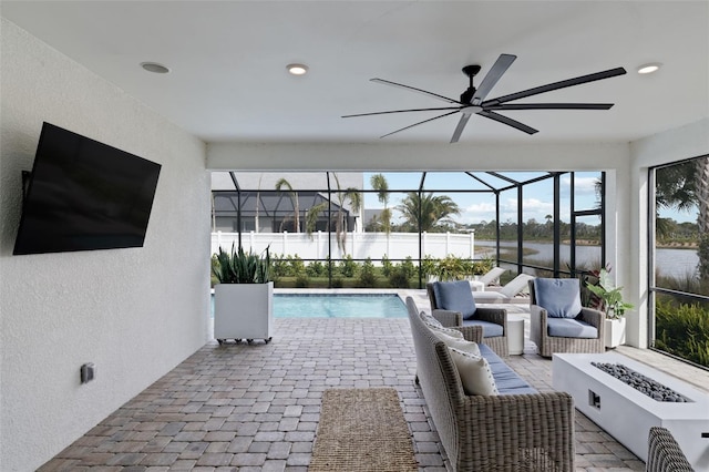 view of patio with a water view, ceiling fan, glass enclosure, and a fenced in pool