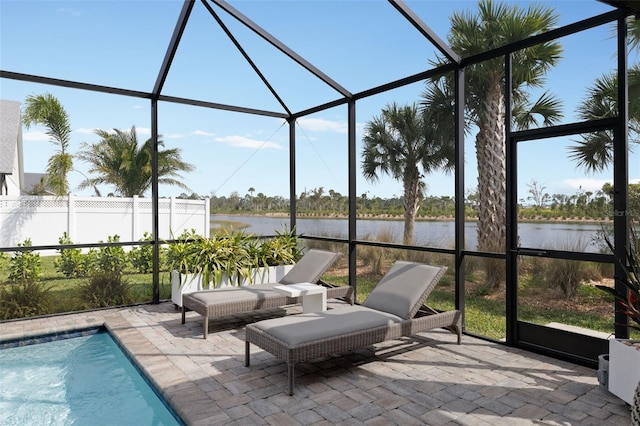 sunroom featuring a water view and a swimming pool