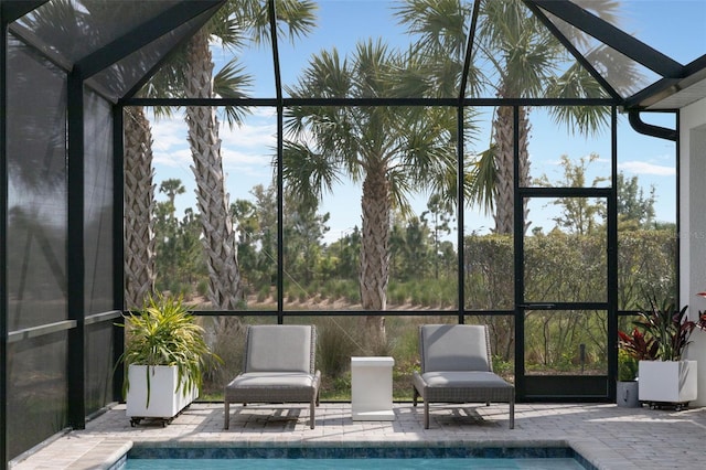 view of swimming pool with a patio area and a lanai