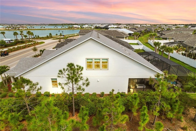 exterior space featuring a lanai and a water view