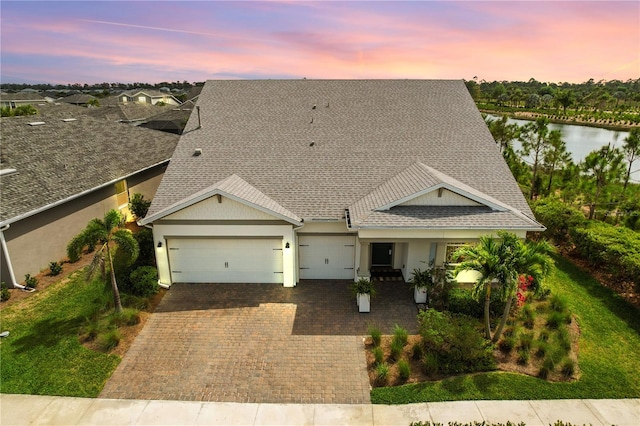 view of front of property featuring a garage and a water view