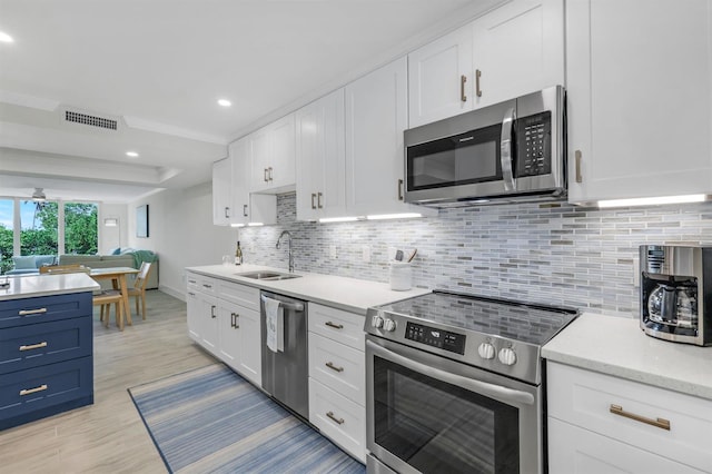 kitchen with stainless steel appliances, sink, and white cabinets