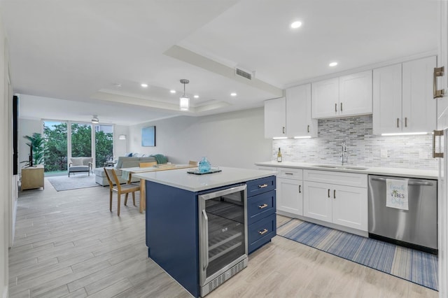 kitchen with white cabinetry, wine cooler, dishwasher, sink, and a raised ceiling