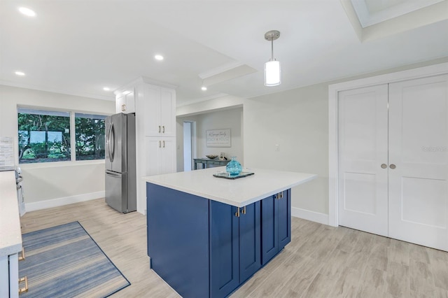 kitchen with light hardwood / wood-style floors, stainless steel fridge, white cabinetry, and decorative light fixtures