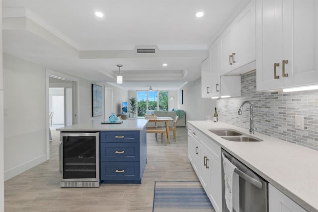 kitchen featuring blue cabinets, white cabinetry, beverage cooler, and a tray ceiling