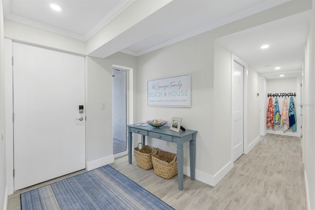 foyer featuring light wood-type flooring and ornamental molding