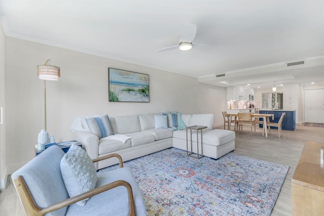 living room featuring light wood-type flooring and ceiling fan