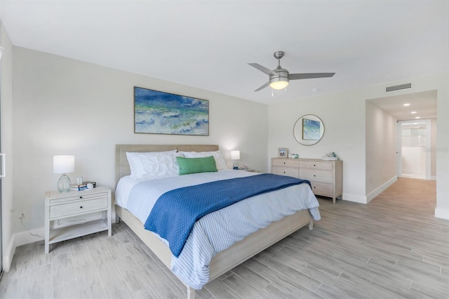 bedroom featuring ceiling fan, light wood-type flooring, and ensuite bathroom