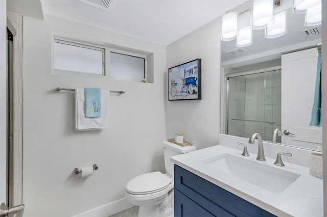 bathroom featuring vanity, toilet, and a shower with shower door