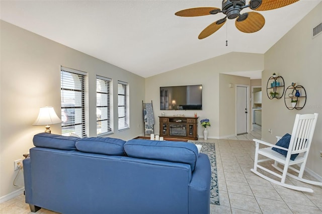 living room with ceiling fan, light tile patterned floors, a fireplace, and vaulted ceiling