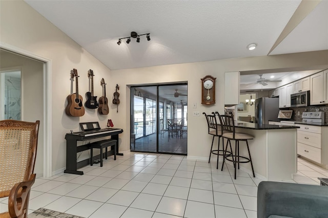 tiled dining room featuring a textured ceiling and ceiling fan