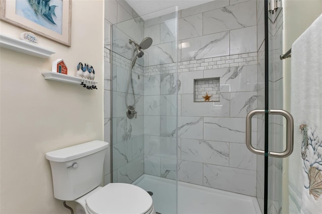 bathroom with a shower with shower door and toilet