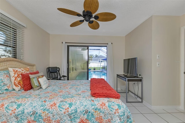 tiled bedroom with ceiling fan, access to exterior, and a textured ceiling