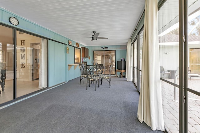 unfurnished sunroom with ceiling fan