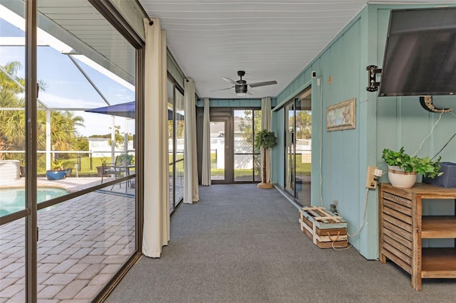 unfurnished sunroom featuring ceiling fan