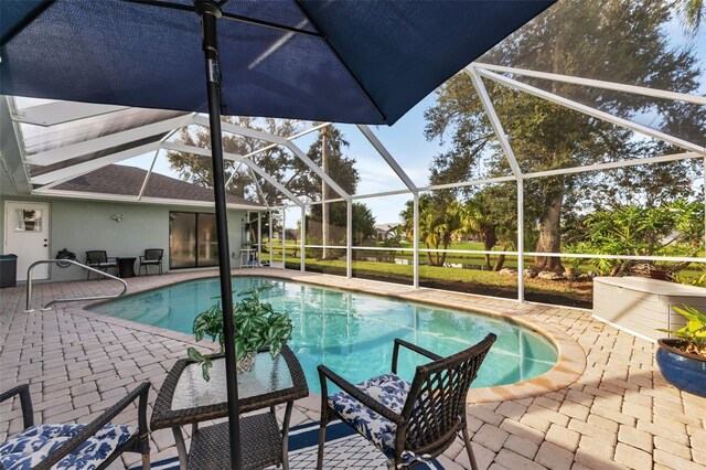 view of pool featuring glass enclosure and a patio