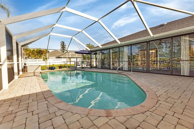 view of pool featuring glass enclosure and a patio area