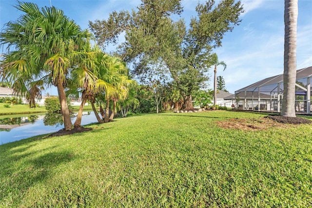 view of yard featuring a lanai and a water view