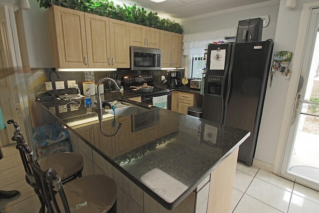 kitchen featuring dark stone counters, kitchen peninsula, sink, range with electric cooktop, and black fridge