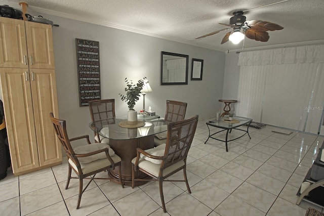 tiled dining room with ceiling fan, ornamental molding, and a textured ceiling