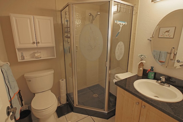 bathroom with vanity, toilet, an enclosed shower, and tile patterned flooring