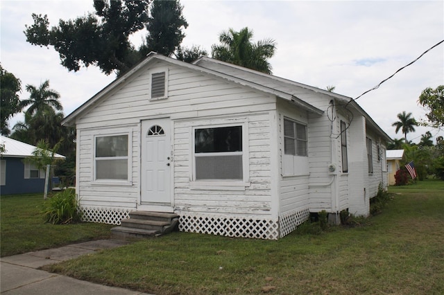 bungalow-style home featuring a front yard