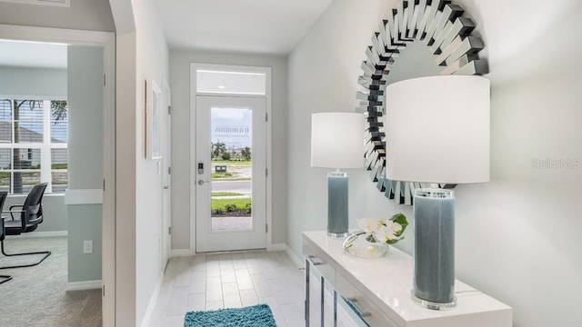 doorway to outside featuring light colored carpet