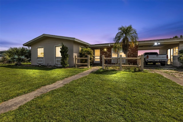 ranch-style home featuring a garage and a yard