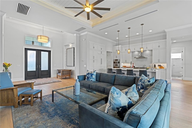 living room featuring ceiling fan, plenty of natural light, and light hardwood / wood-style floors