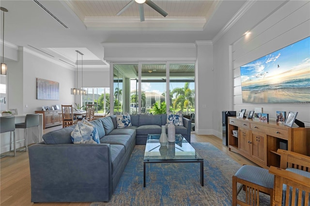 living room with ceiling fan, crown molding, a raised ceiling, and wood-type flooring