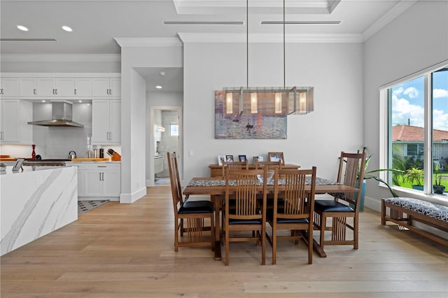 dining space featuring crown molding and light hardwood / wood-style flooring