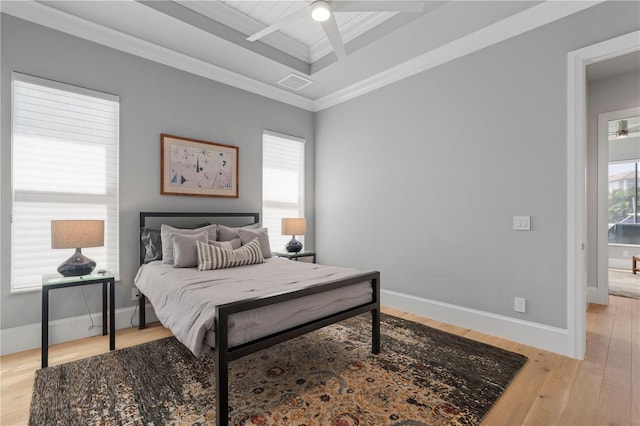 bedroom featuring ornamental molding, light hardwood / wood-style flooring, beam ceiling, and ceiling fan