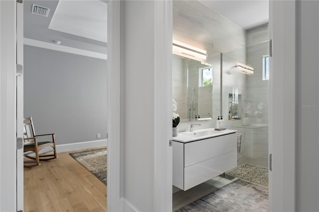 bathroom featuring a shower with door, vanity, and hardwood / wood-style floors