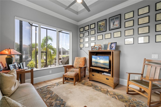 living area with light wood-type flooring, ceiling fan, and crown molding