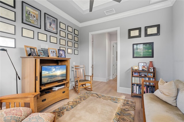 living room featuring crown molding and light hardwood / wood-style floors