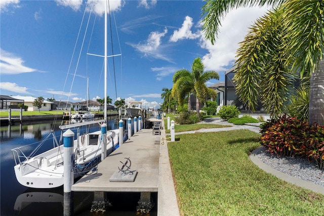 view of dock with a water view and a yard