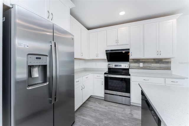 kitchen featuring stainless steel appliances, tasteful backsplash, light stone counters, light hardwood / wood-style floors, and white cabinets