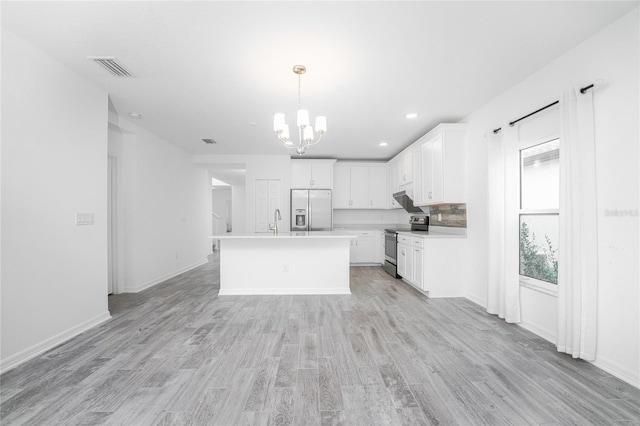 kitchen with sink, appliances with stainless steel finishes, a center island with sink, white cabinets, and light wood-type flooring