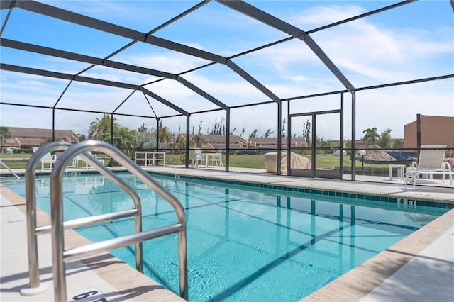 view of pool with a patio area and glass enclosure