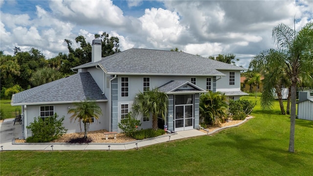 back of house with a yard and a sunroom