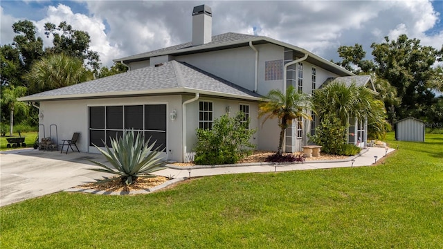 view of front of home featuring a storage unit, a patio, and a front yard