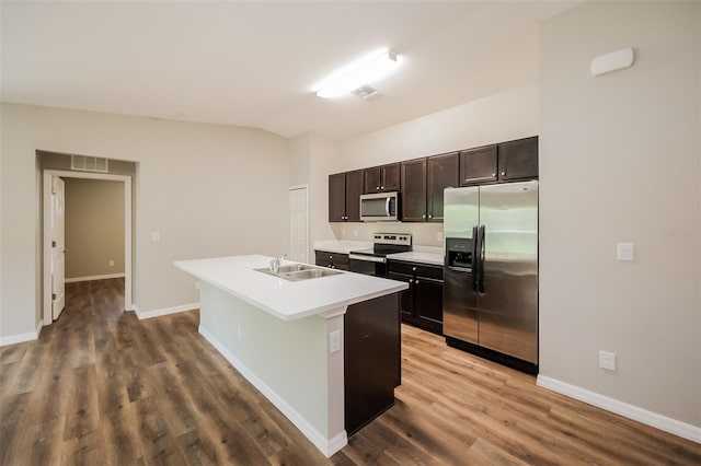 kitchen featuring a kitchen island with sink, appliances with stainless steel finishes, hardwood / wood-style floors, and sink