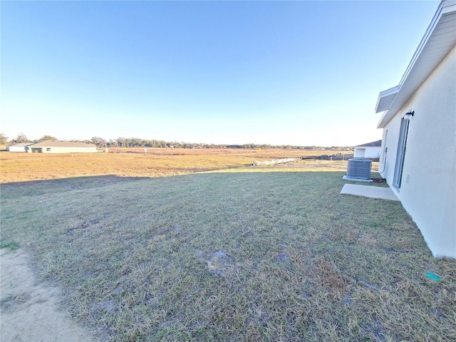 view of yard featuring central AC unit and a rural view