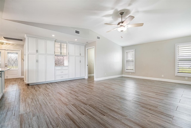 unfurnished living room with light wood-type flooring, ceiling fan, and vaulted ceiling