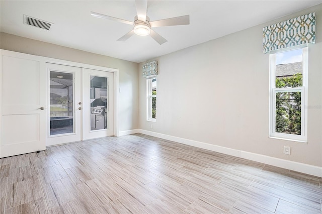 empty room featuring a healthy amount of sunlight, ceiling fan, and light hardwood / wood-style floors