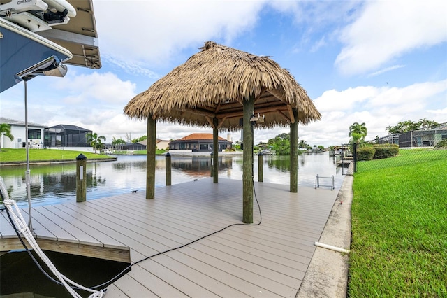 view of dock with a water view, a yard, and glass enclosure