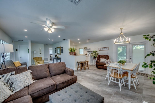 living room with french doors and ceiling fan with notable chandelier